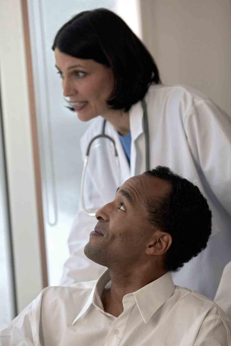 female doctor smiling and looking out of the window with male patient