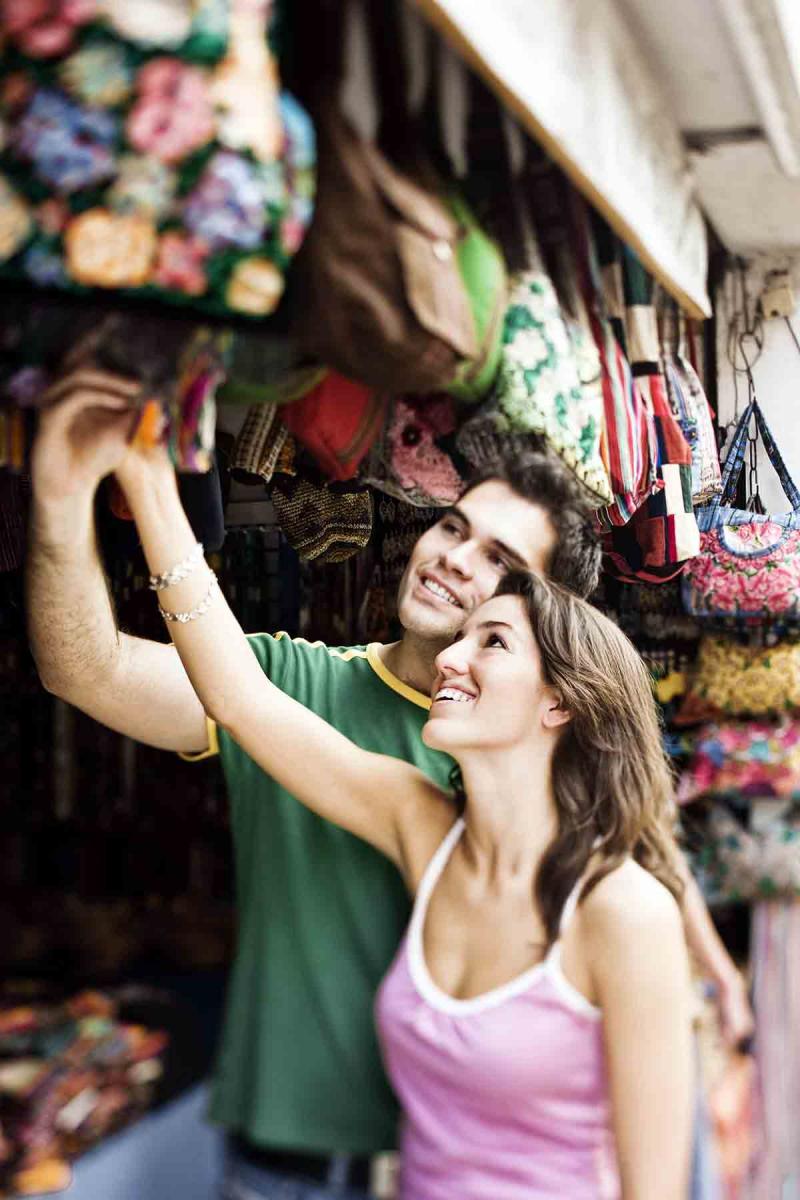 a young man and young woman shop together in an outdoor market