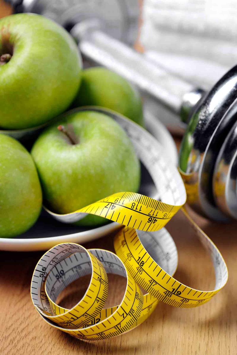 apples, free weights and a tape measure on a tabletop