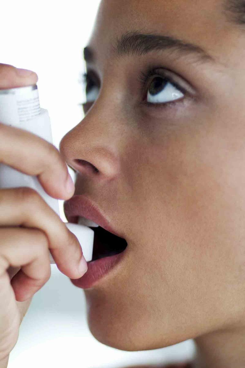 young woman using an asthma inhaler