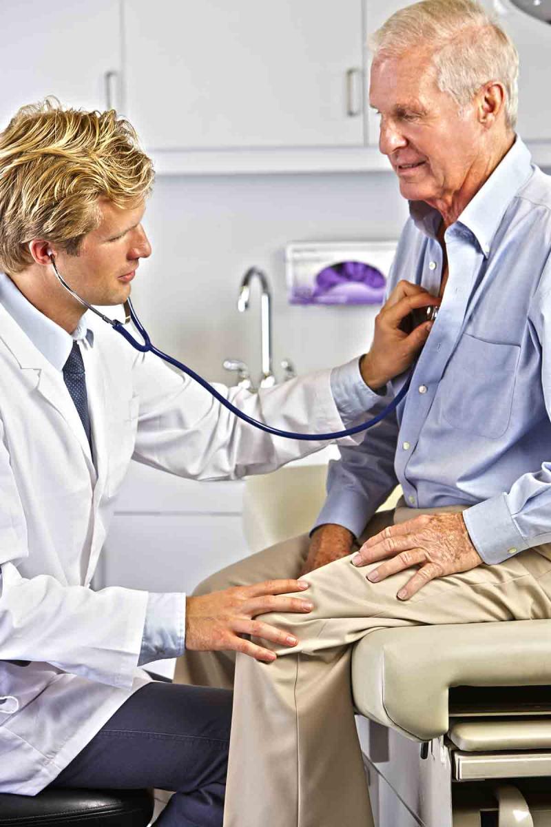 a male physician examines an older male patient
